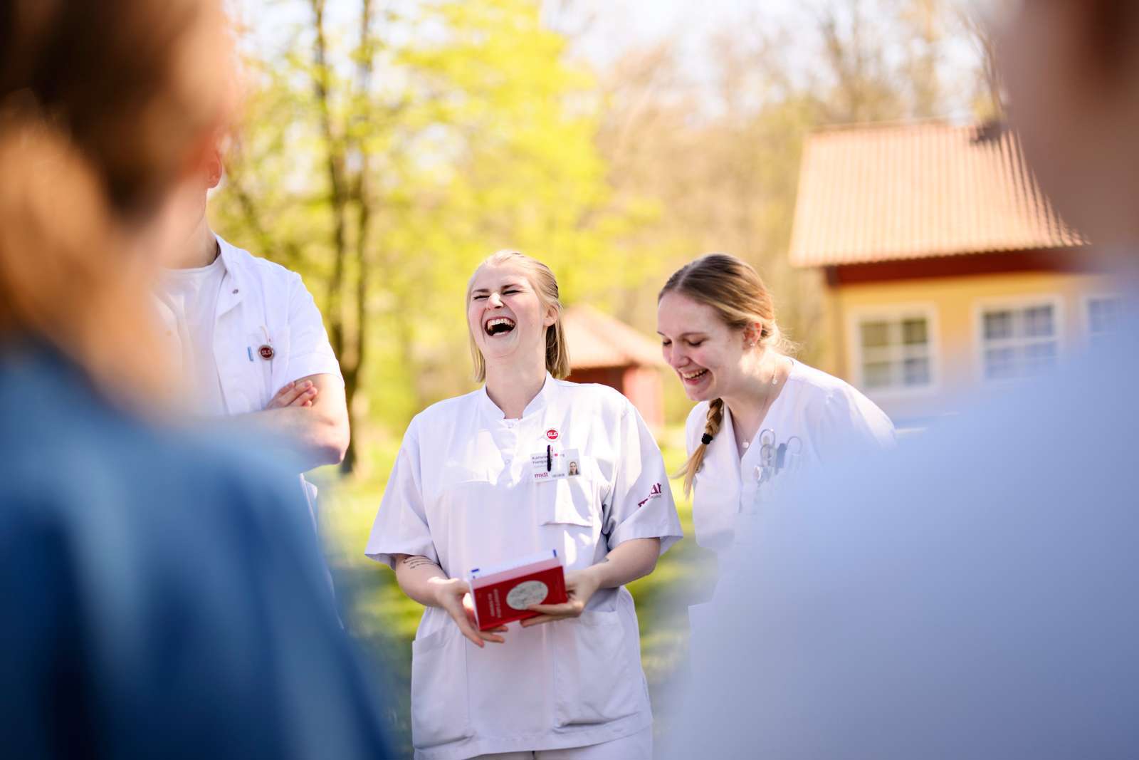 Glade sygeplejestuderende griner udendørs