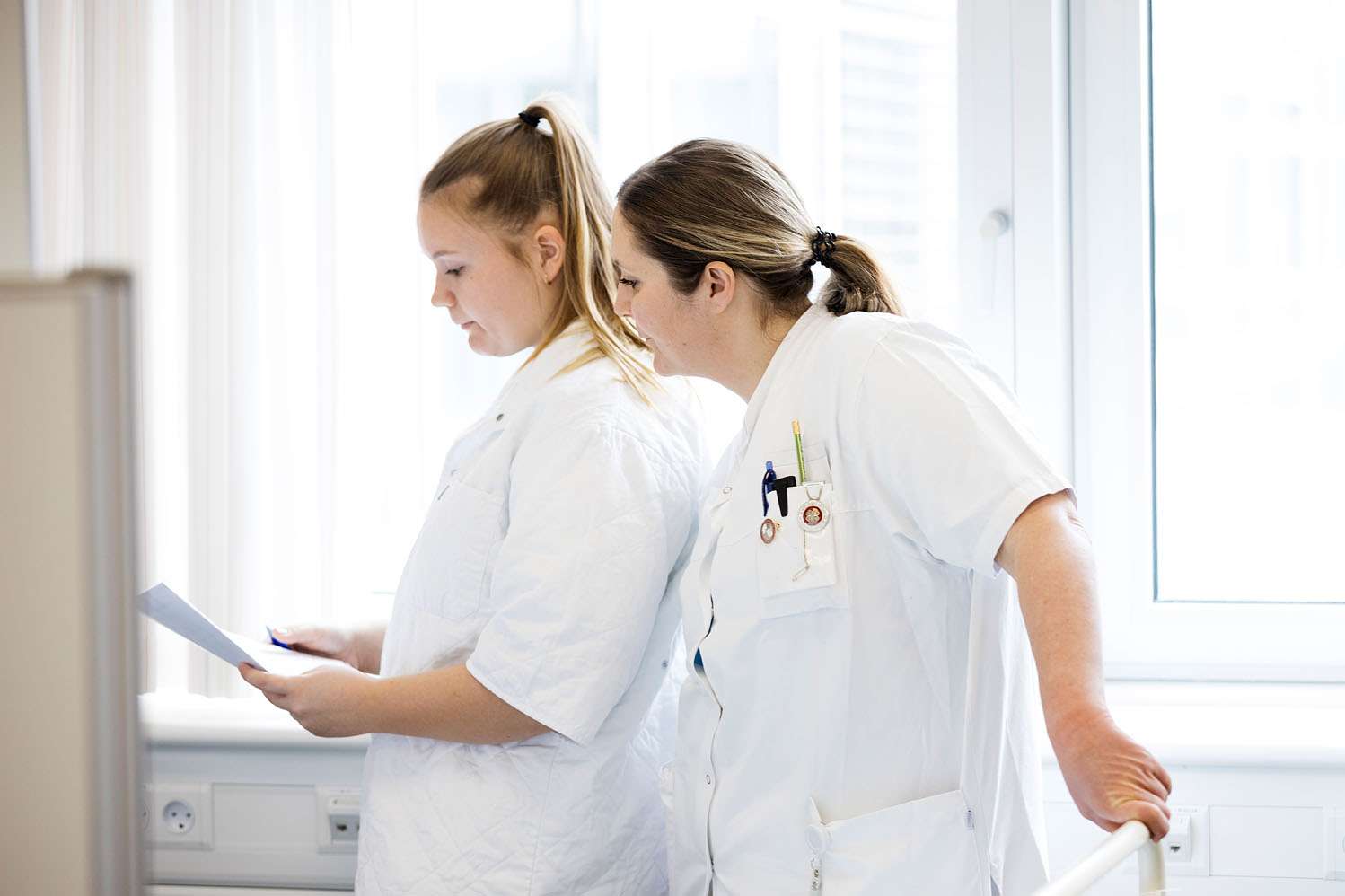 To sygeplejersker kigger på et dokument. 