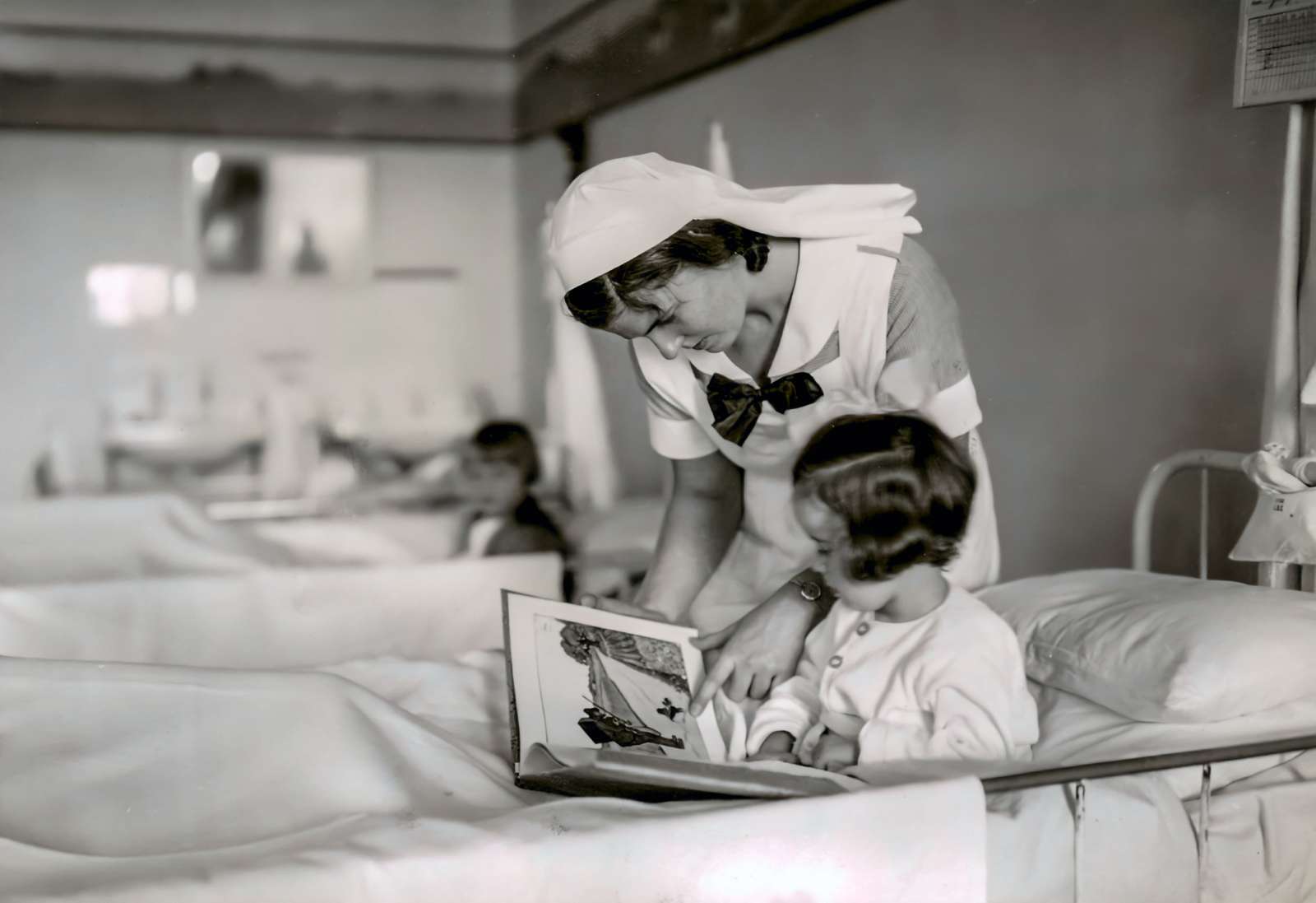 Aalborg Amtssygehus. Sygeplejeelev med læser for en sengeliggende pige.jpg