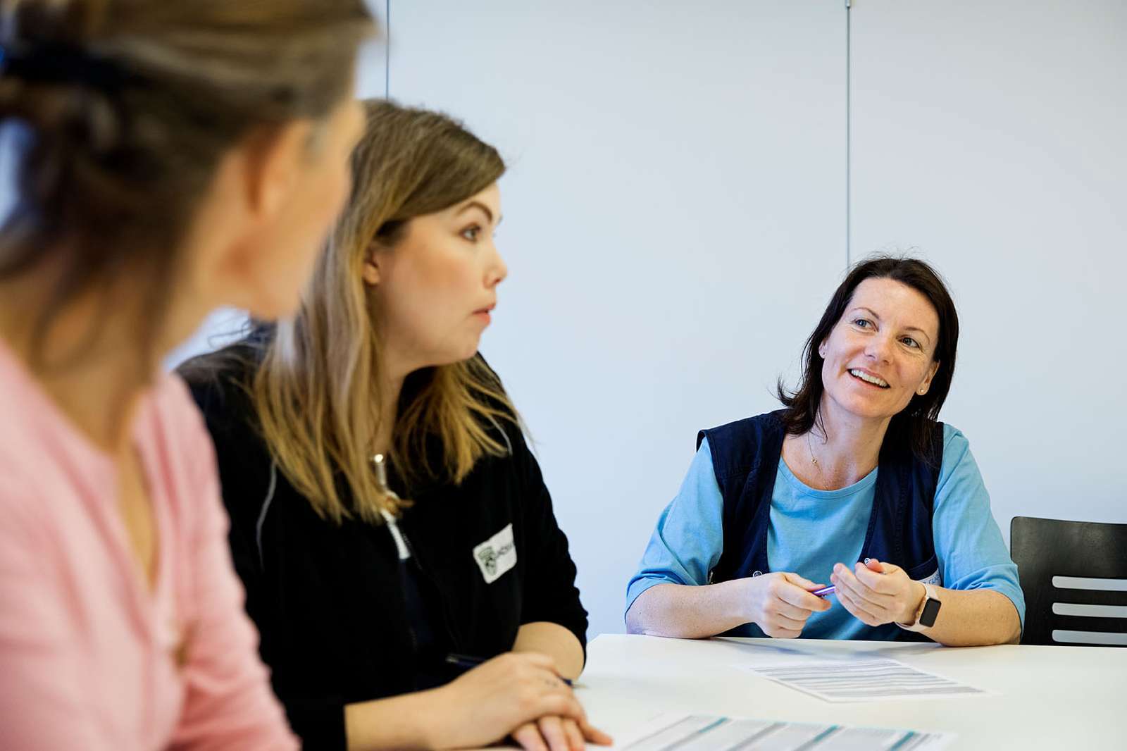 Sygeplejersker i dialog på et kontor.