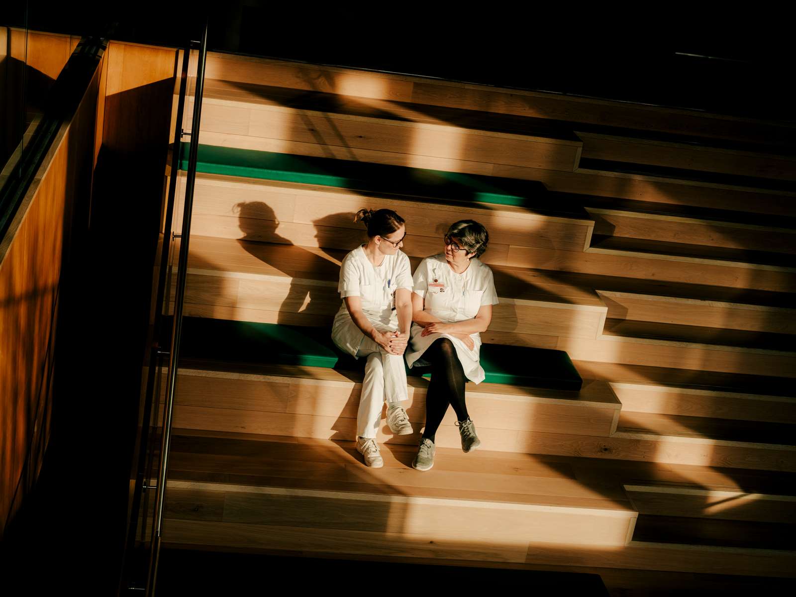 To diabetessygeplejersker sidder på en trappe og snakker