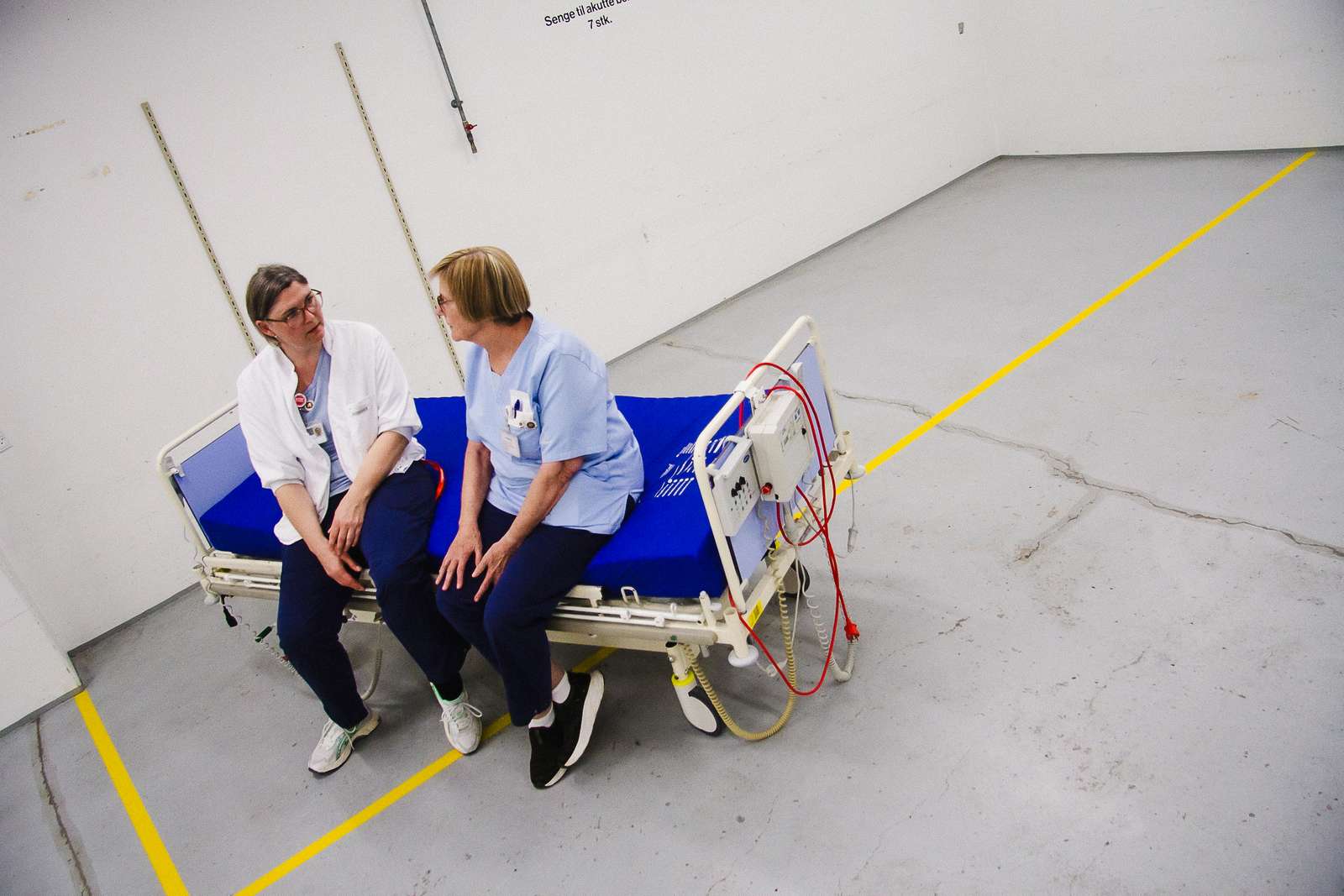 To sygeplejersker sidder i en patientseng
