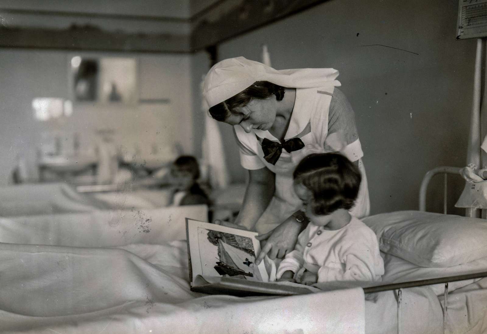 Aalborg Amtssygehus. Sygeplejeelev med læser for en sengeliggende pige