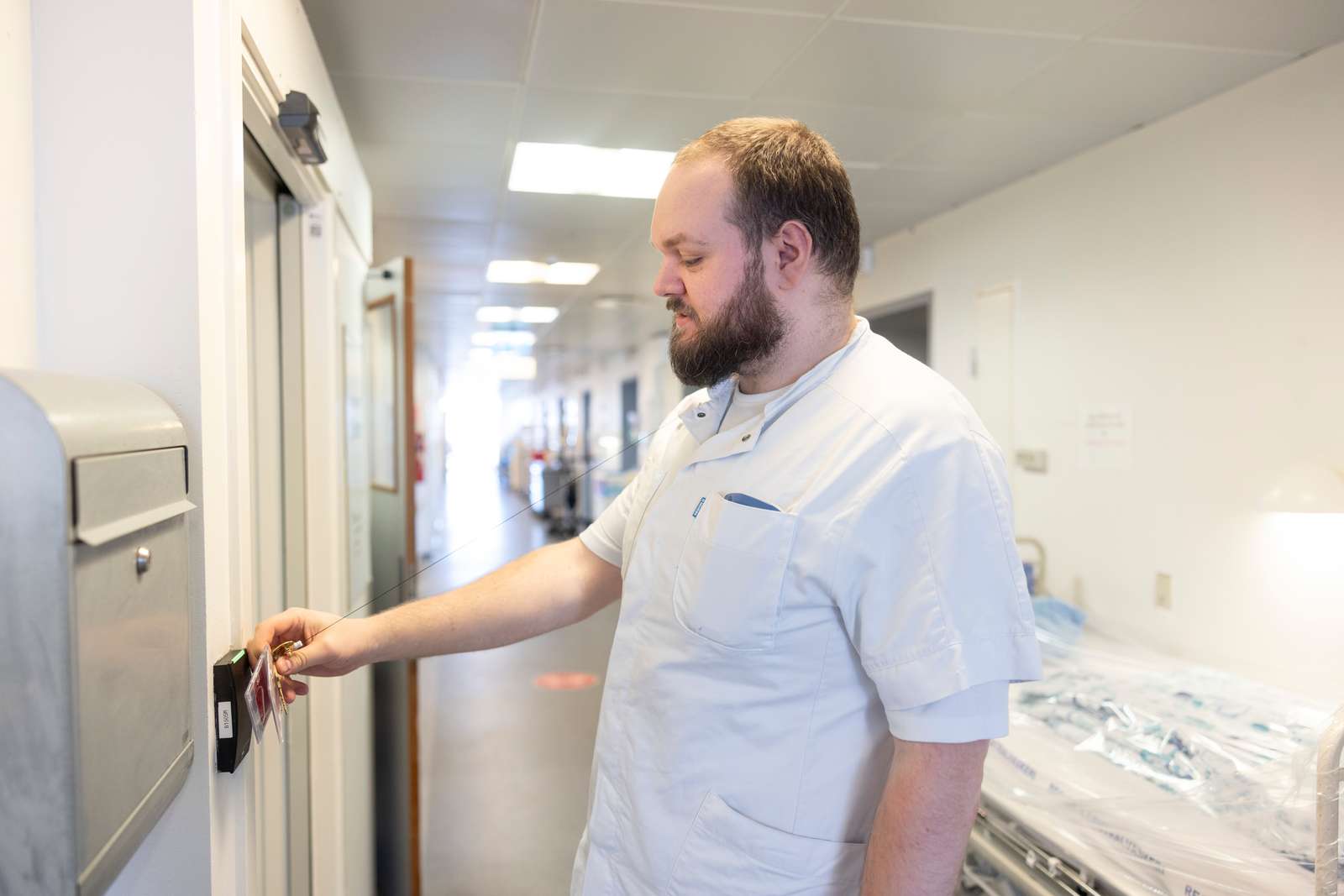 Sygeplejerske, der scanner sit kort ved en dør