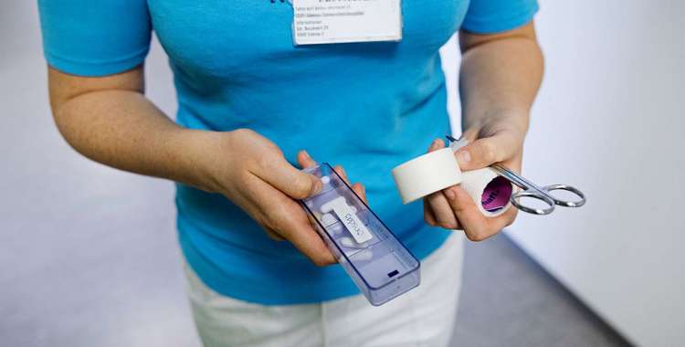 En sygeplejerske med en pilleæske.