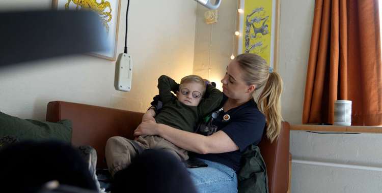 Barn på skødet af en sygeplejerske